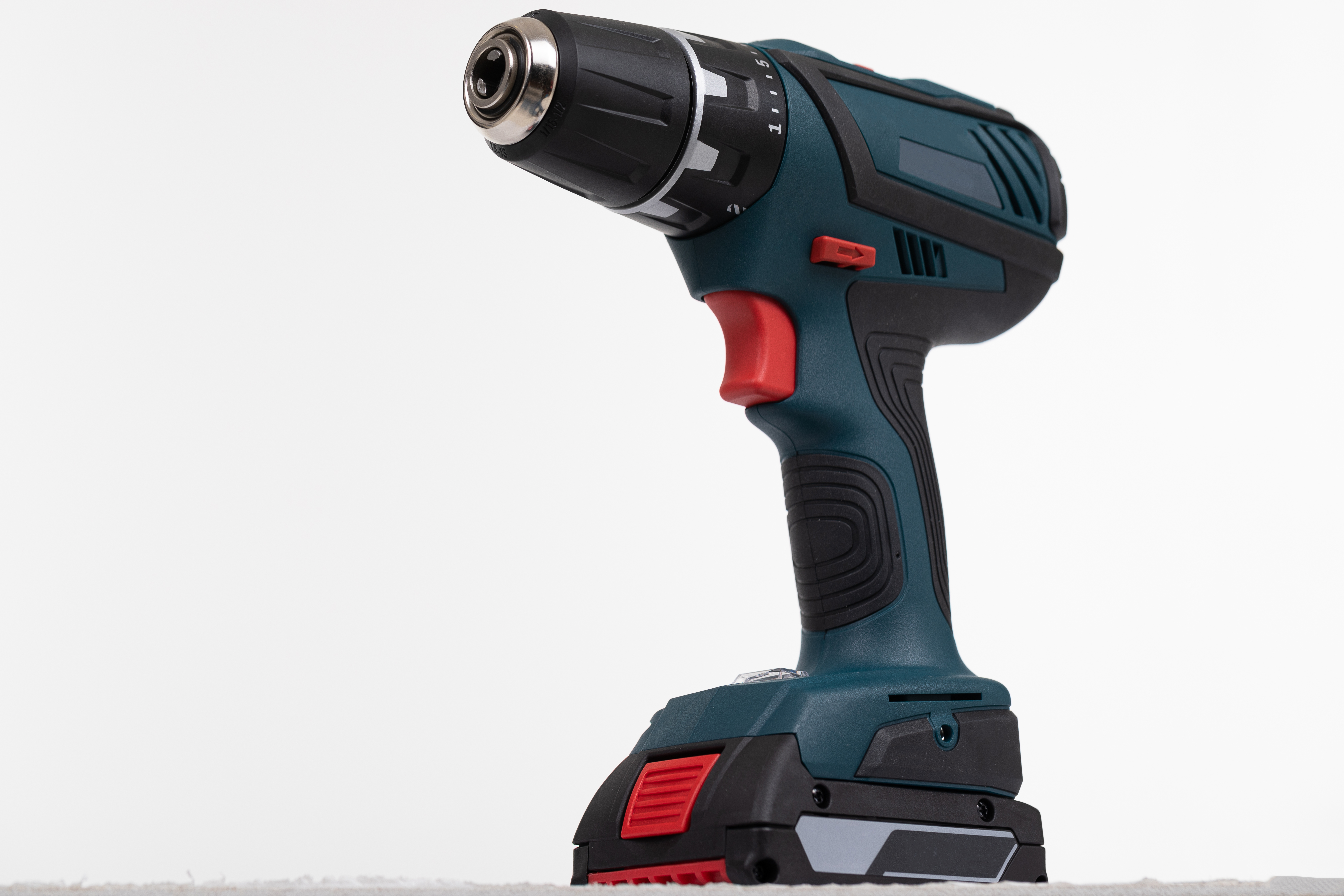 Cordless electric drill close-up on white wall
